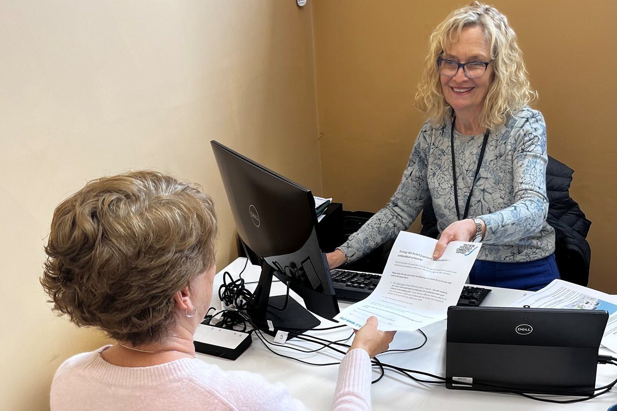 An SPCS support worker going through paperwork with a client