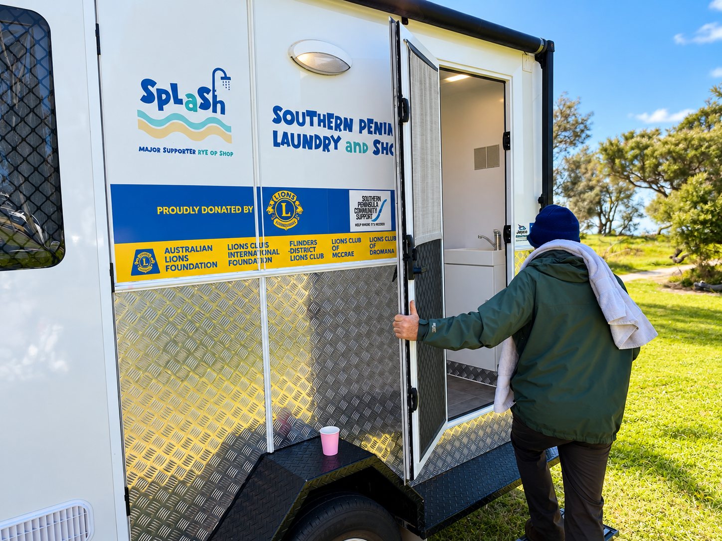 Someone stepping into the SPLaSh mobile shower and laundry trailer